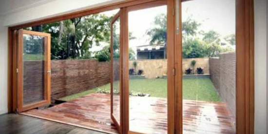 Timber bifold doors opened onto a decked courtyard garden