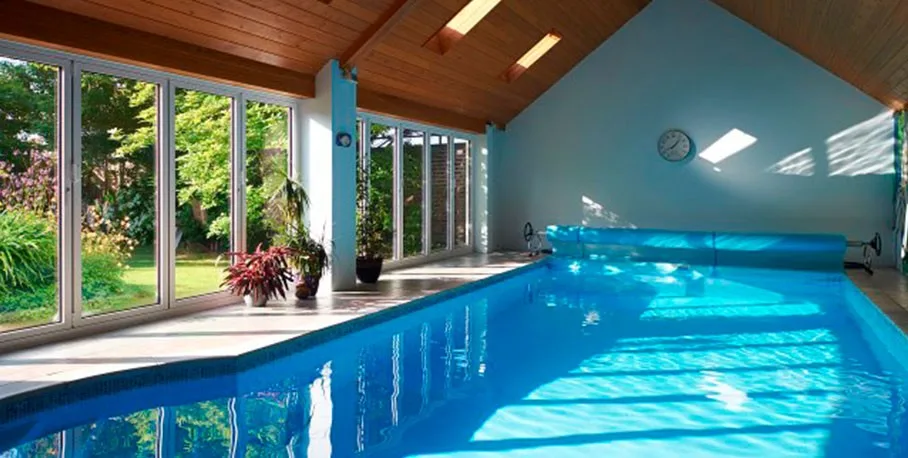 Cortizo aluminium bi-fold door beside a swimming pool in daylight