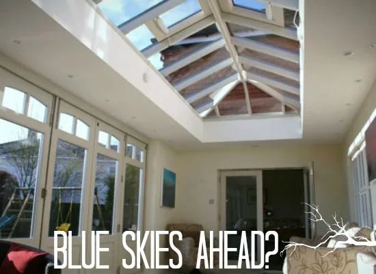 Interior of an orangery with a glazed roof lantern and white timber doors