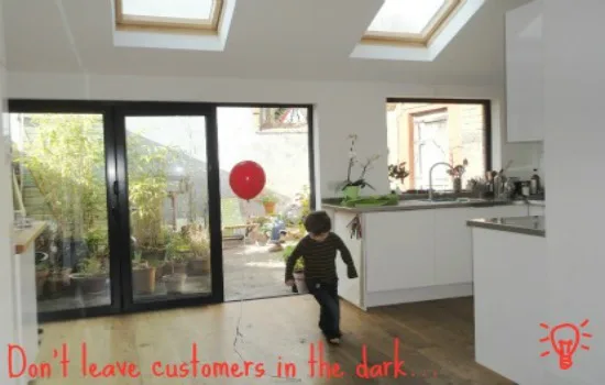 Child with a red balloon running through a kitchen with black bifold doors