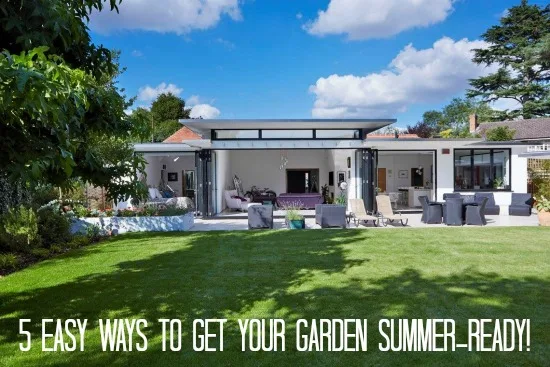 Three sets of bifold doors open across the rear of a white rendered house