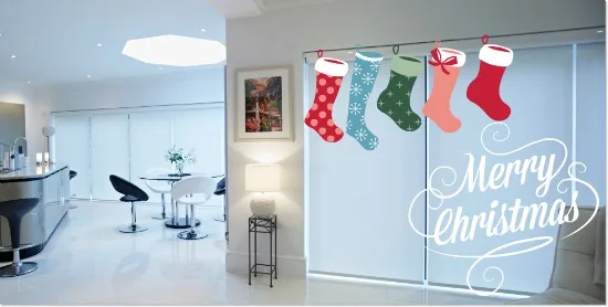 Christmas stockings hung across a glazed wall in a white interior