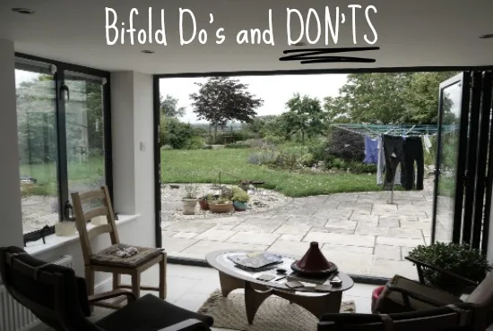 Living room looking out through open bifold doors onto a garden