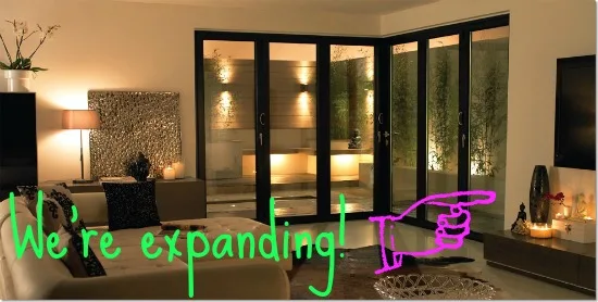 Dark bifold doors in a warmly lit lounge at night