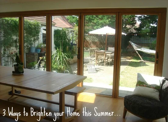 Timber bifold doors opening from a dining room onto a summer garden