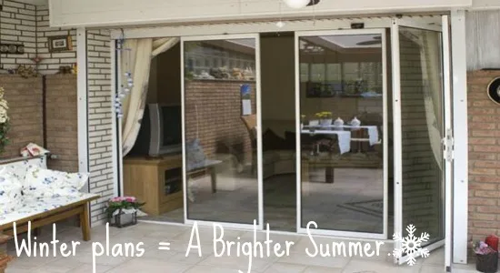 White slide-and-stack doors across the rear of a bungalow