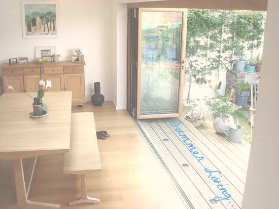 Dining room with bifold doors open onto a small courtyard