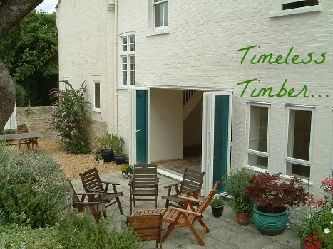Timber doors open onto a courtyard at a white-painted period house